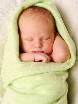 a baby wrapped in a green blanket